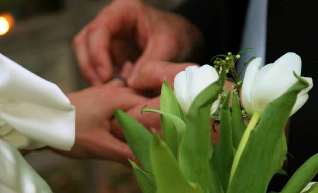 hands with wedding ring and flowers